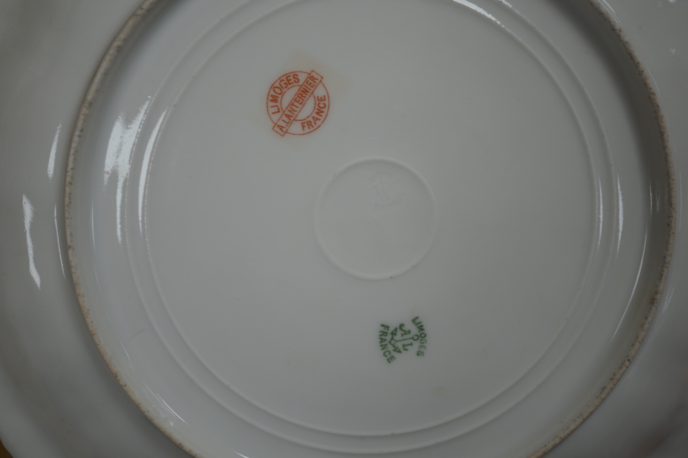 A Limoges dessert service decorated with birds and flowers, the largest 27cm wide